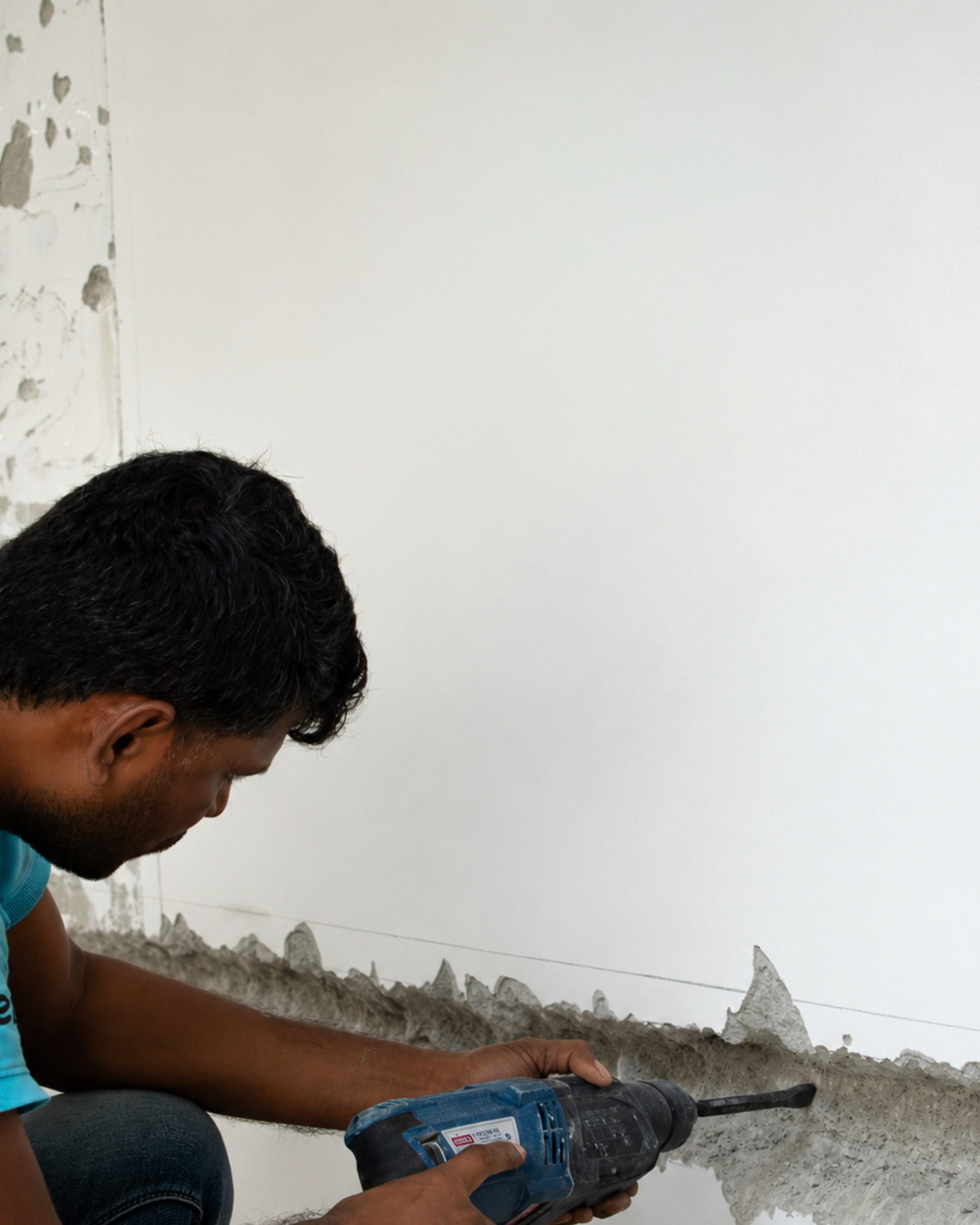 Worker cutting into a lower wall during renovation