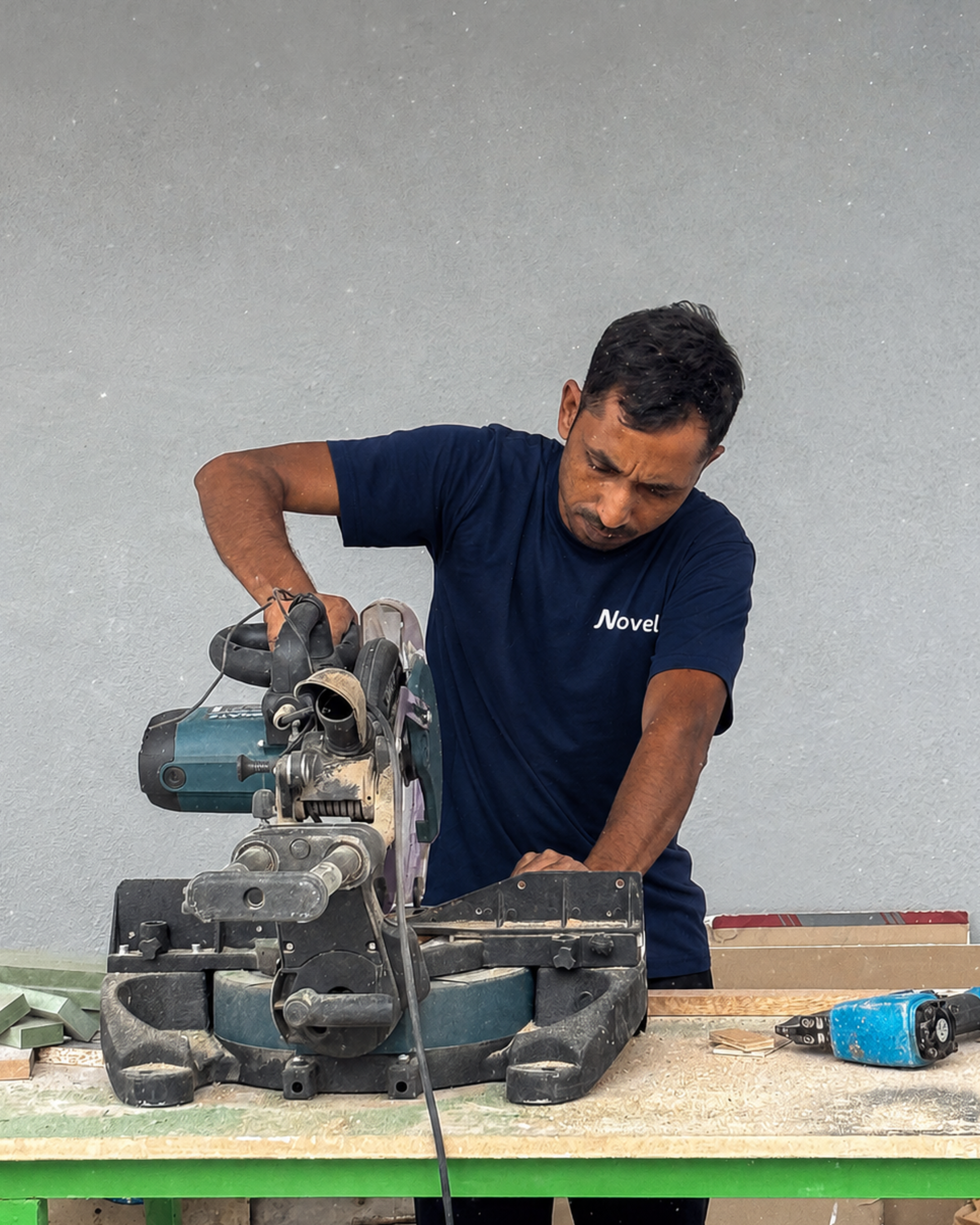 Worker cutting materials with a mitre saw for custom fit-out